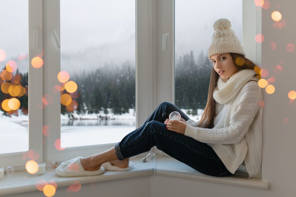 Young woman sitting in the window